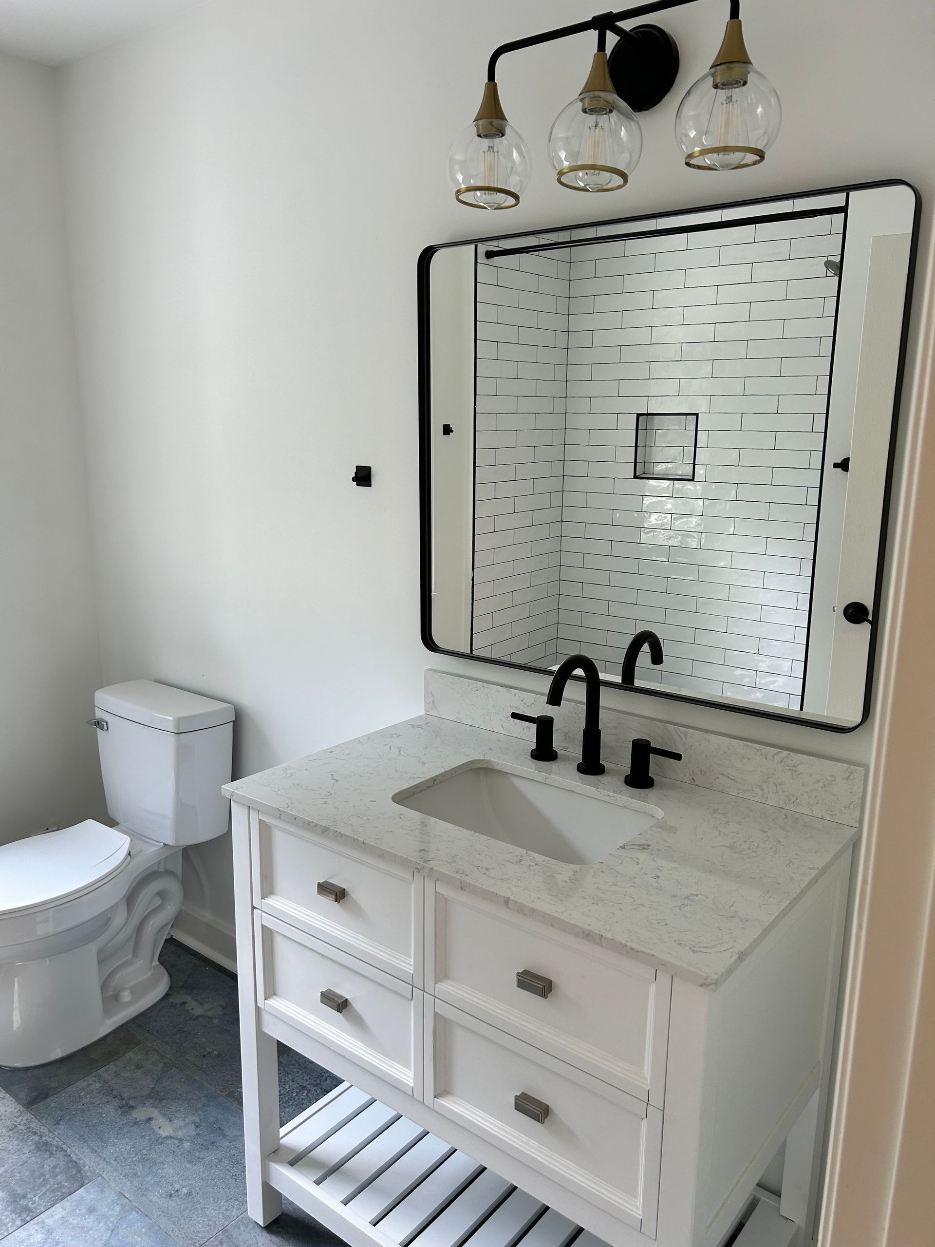 A bathroom with a toilet , sink and mirror