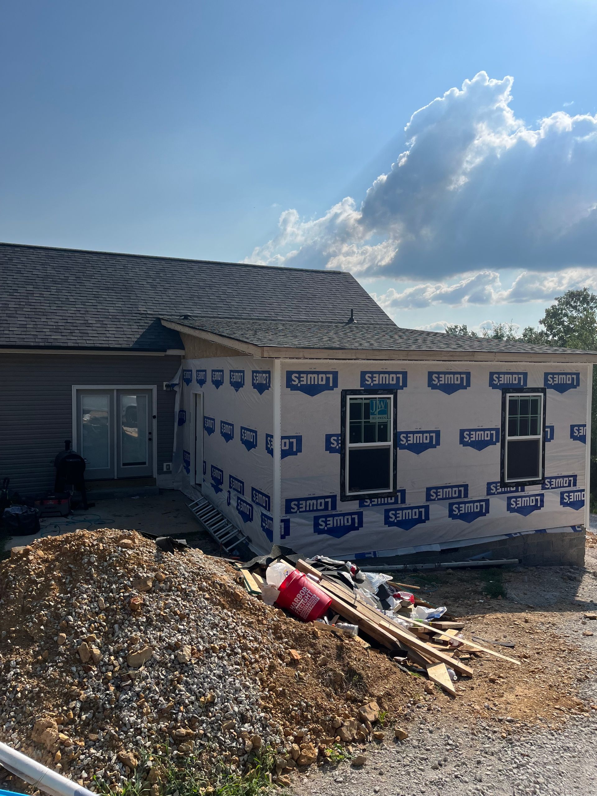 A house is being built in the middle of a dirt field.