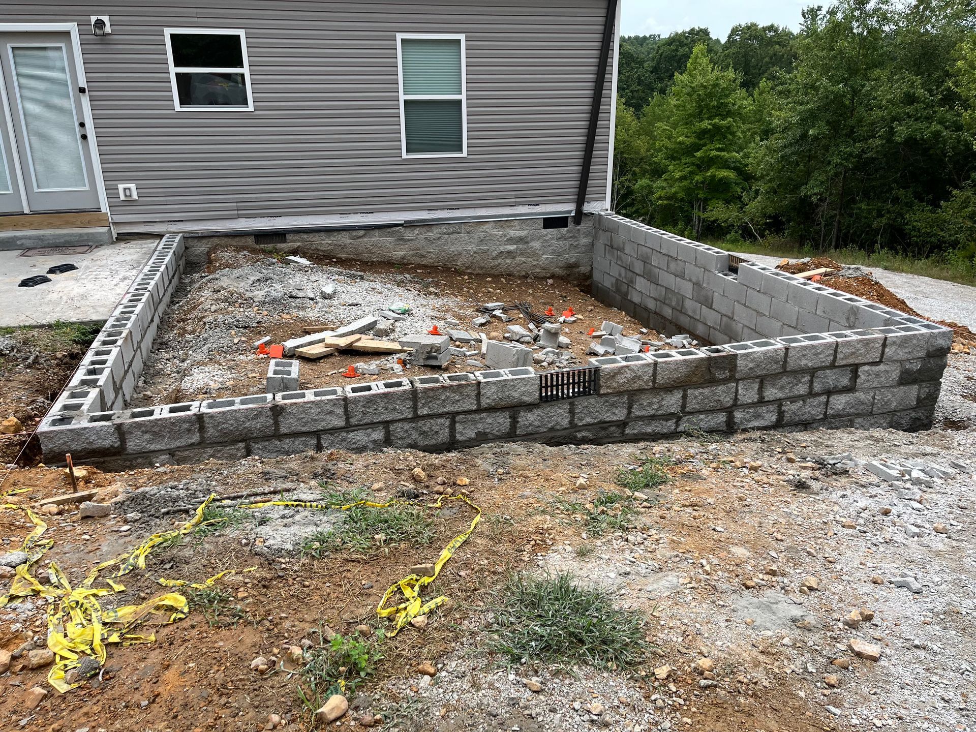 A brick wall is being built in front of a house.