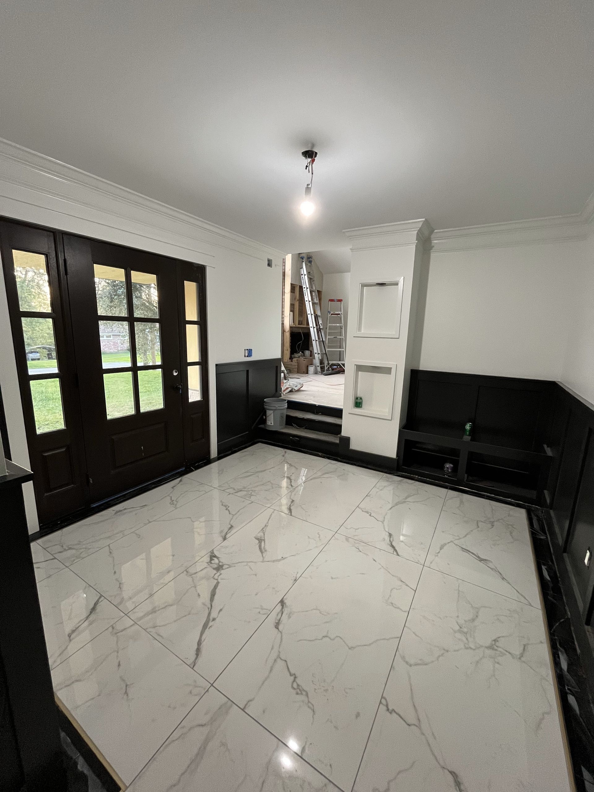 A living room with a marble floor and a wooden door.