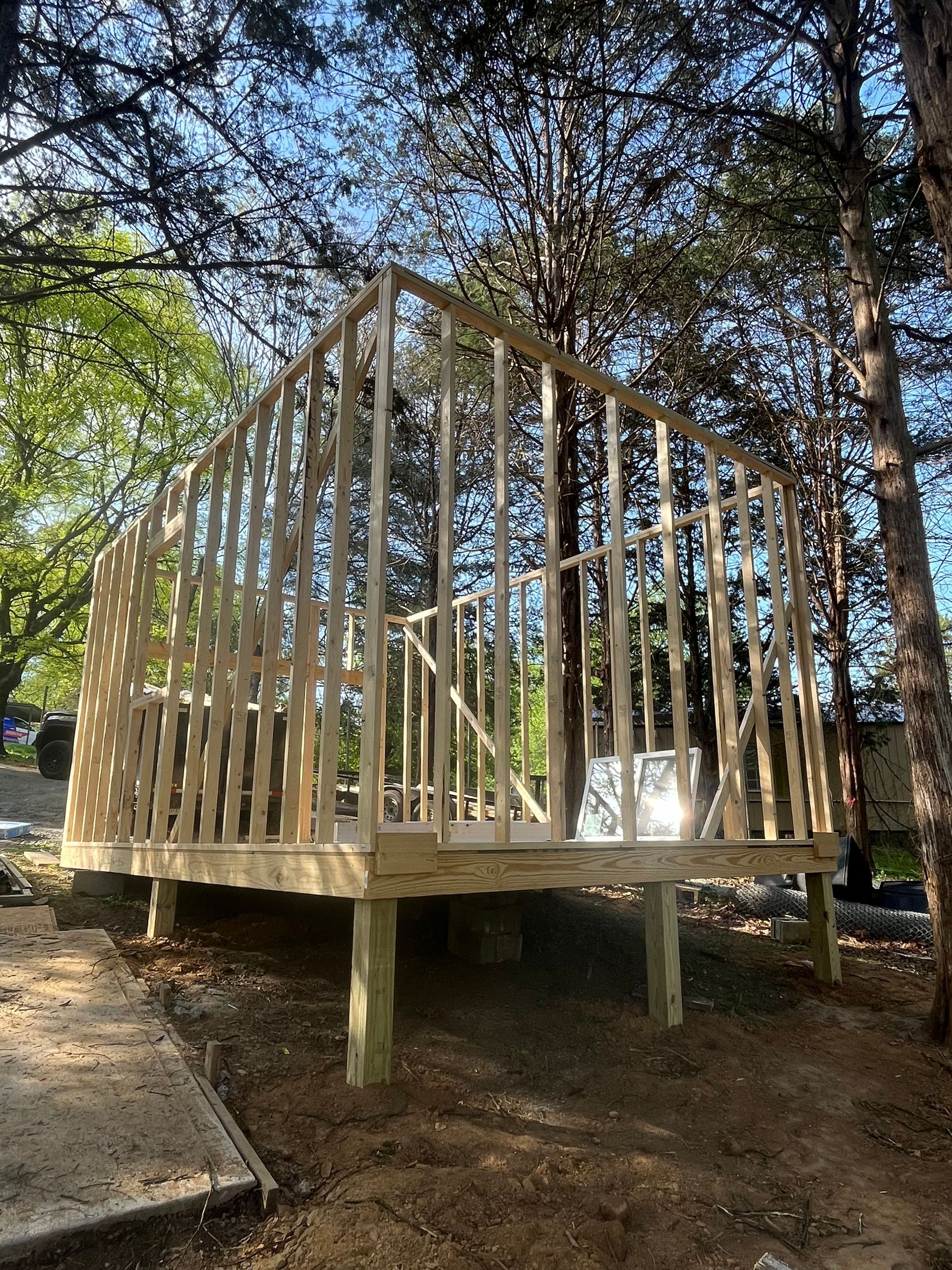 A wooden structure is being built in the middle of a forest.