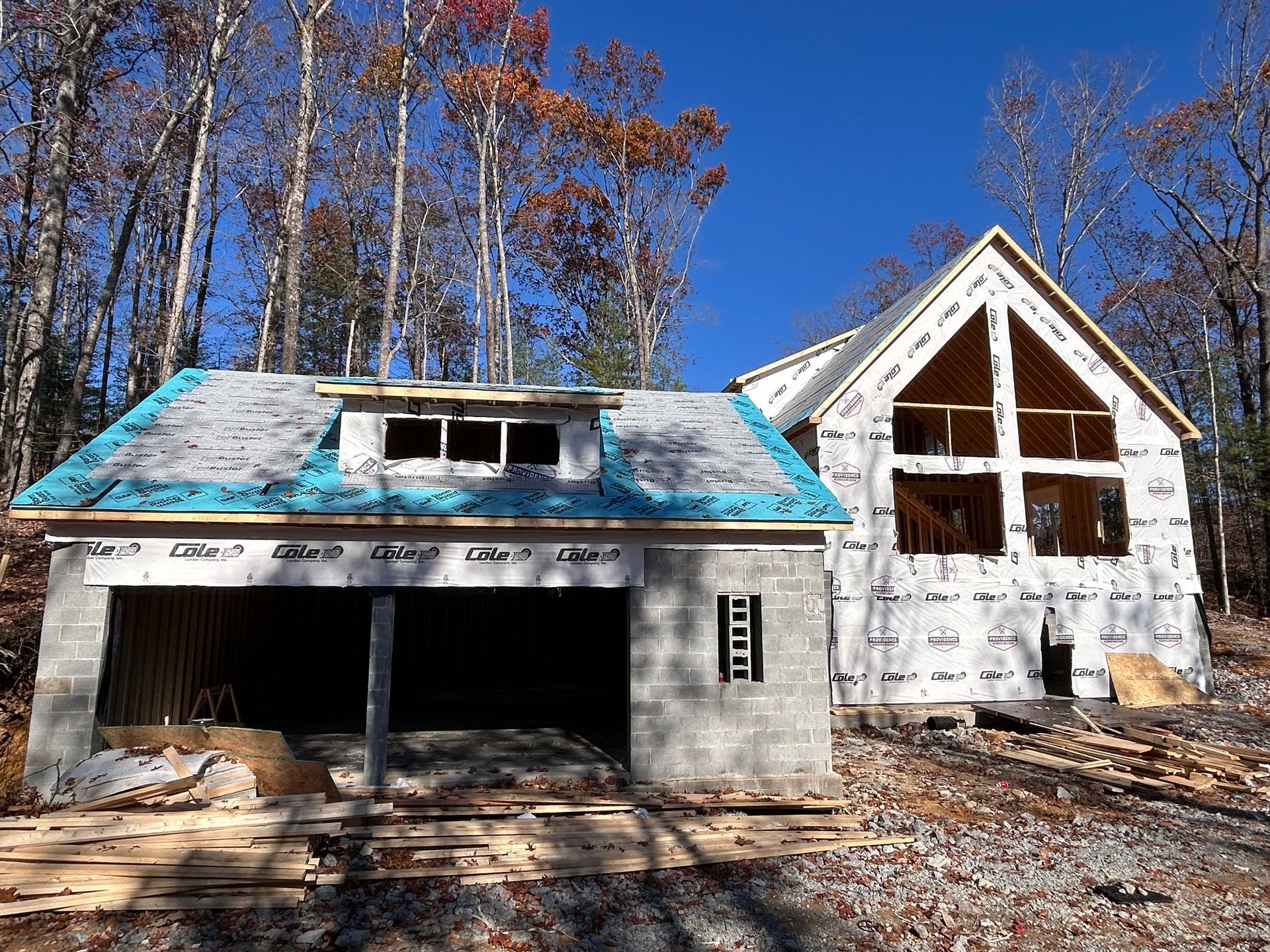 A house is being built in the woods with a blue roof
