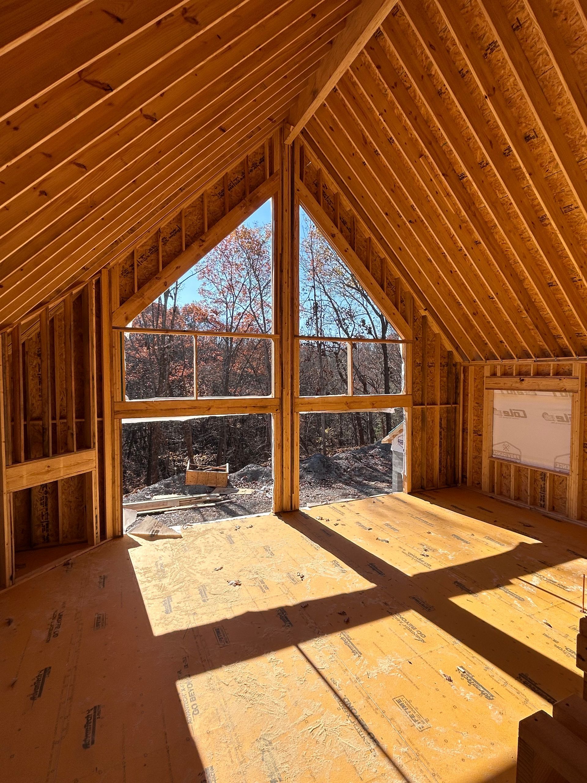 A room in a house under construction with a lot of windows.