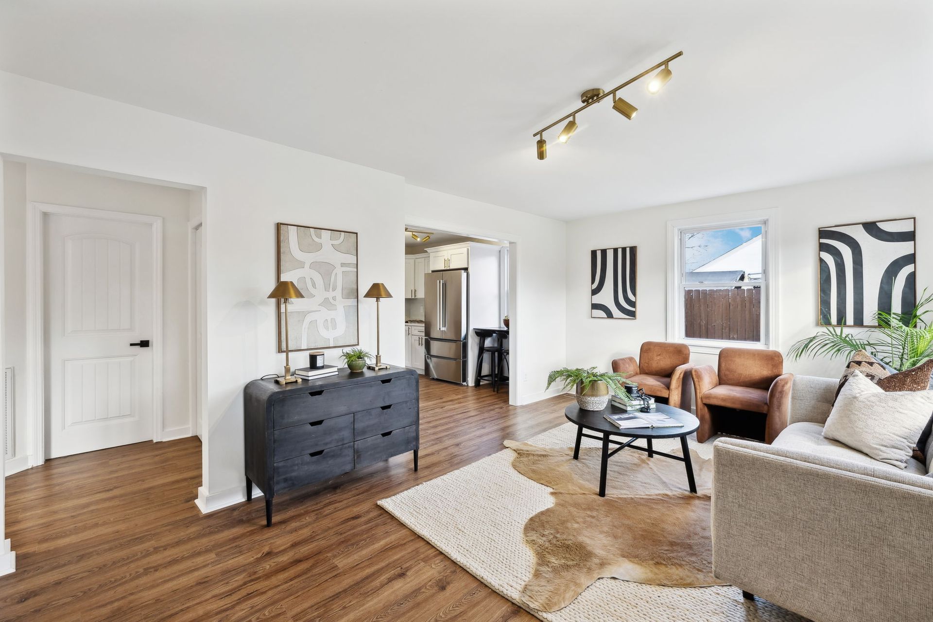 A living room with a couch , chairs , coffee table and dresser.