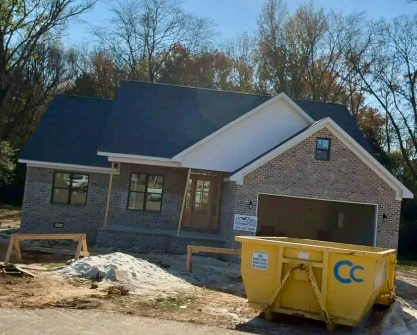 A yellow dumpster with the letter cc on it