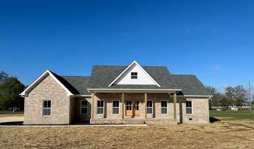A large brick house with a white trim and a gray roof
