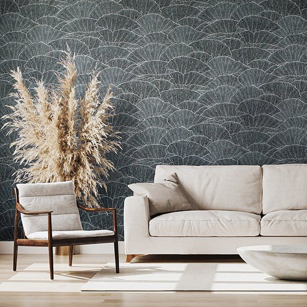 a living room with a couch , chair , and vase of pampas grass .