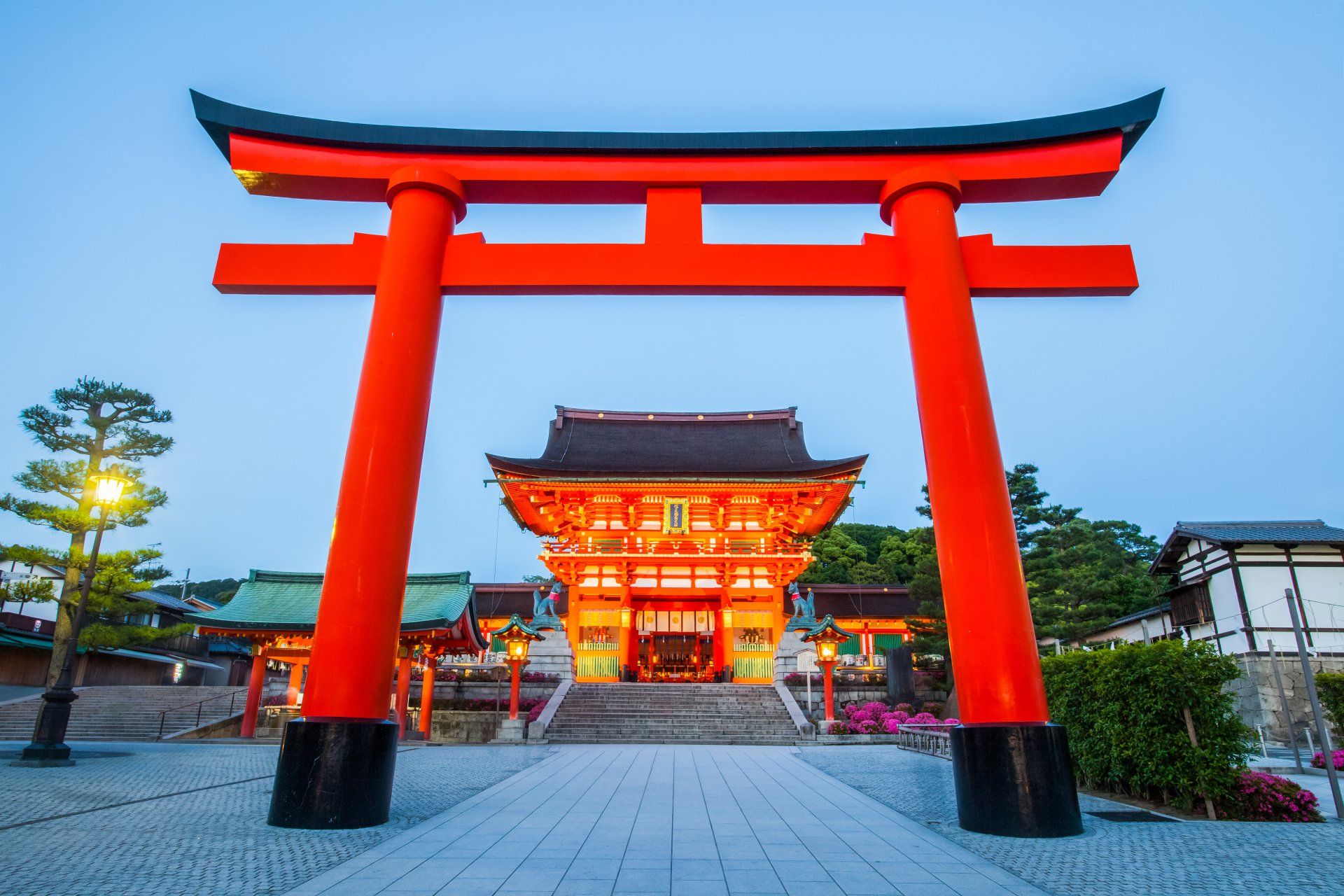 a red torii gate in front of a temple