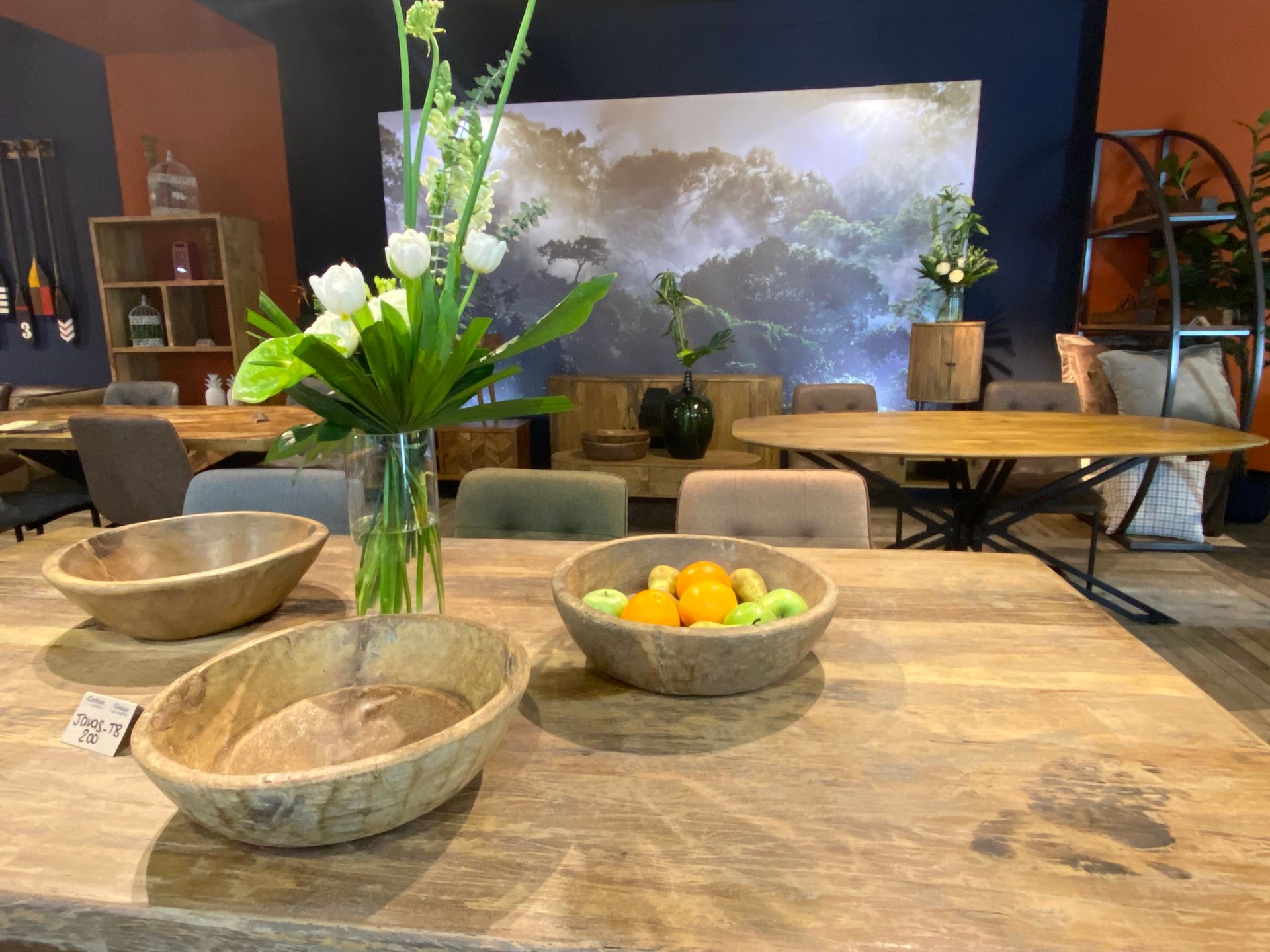 a wooden table with bowls of fruit and flowers on it at the January Furniture Show 2024, NEC, Birmingham