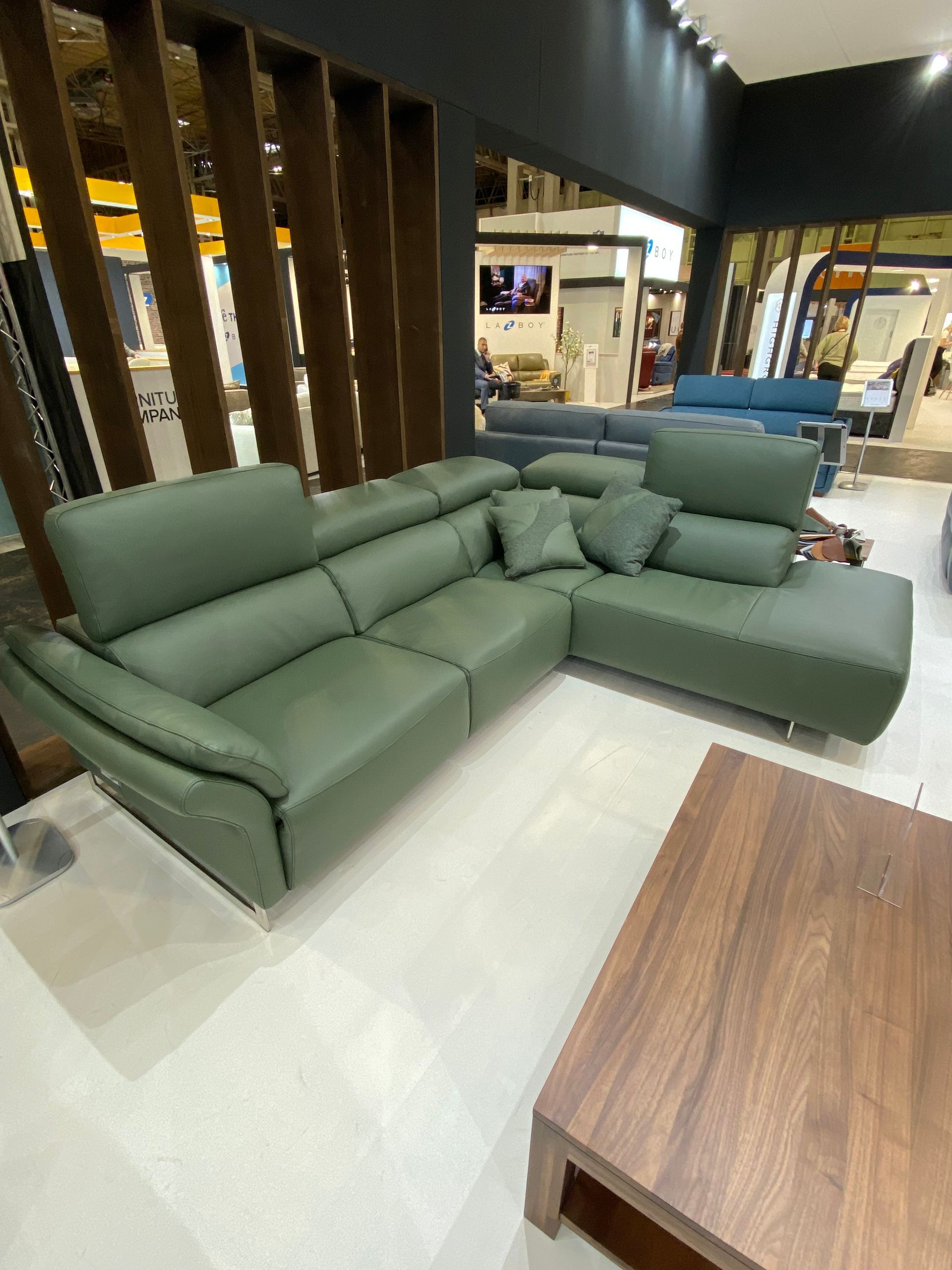 a living room with a green leather sectional couch and a wooden coffee table at the January Furniture Show 2024, NEC, Birmingham