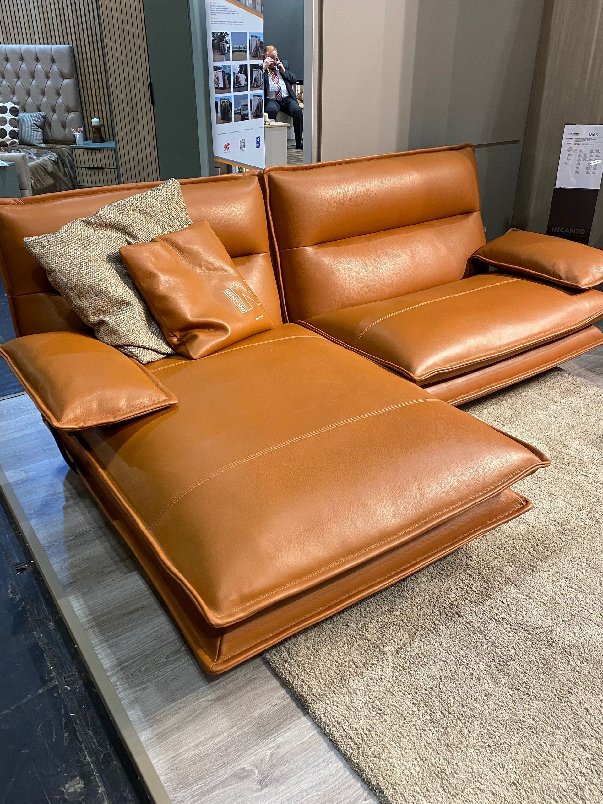 a brown leather sectional couch with pillows on it at the January Furniture Show 2024, NEC, Birmingham