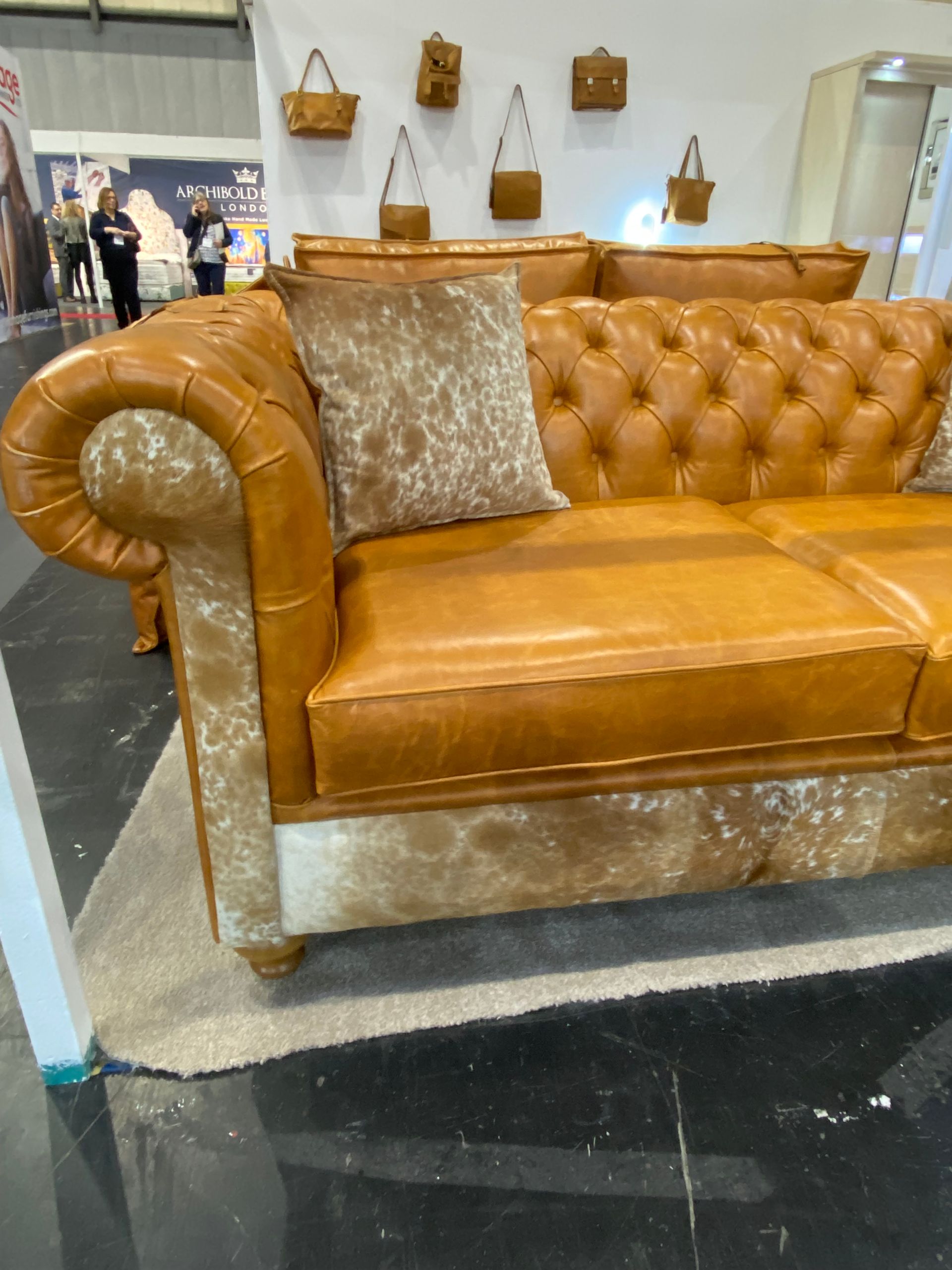 a brown two tone leather hide and skin sofa with two pillows at the January Furniture Show 2024, NEC, Birmingham