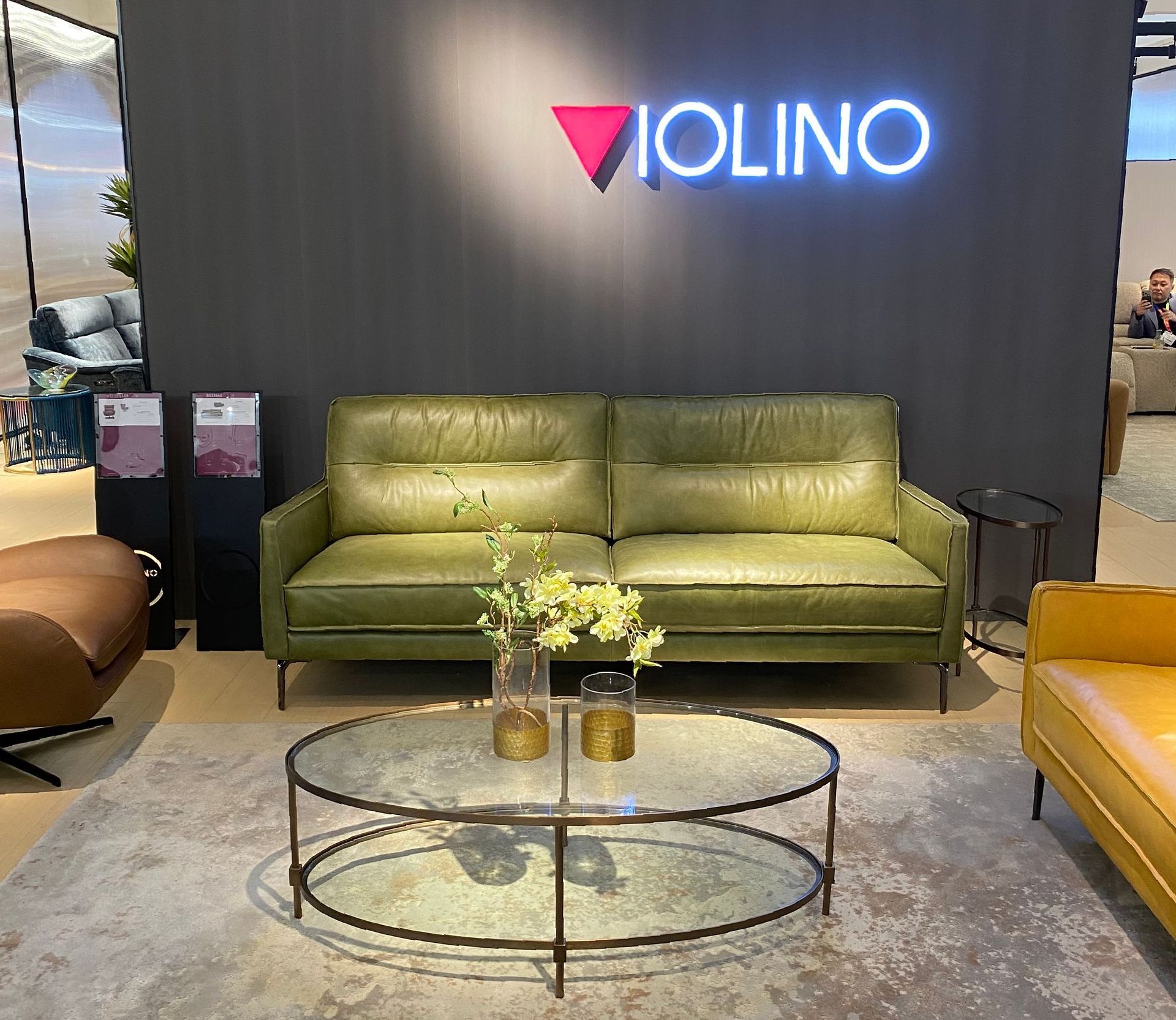 a living room with a green couch and violino branding at the January Furniture Show 2024, NEC, Birmingham