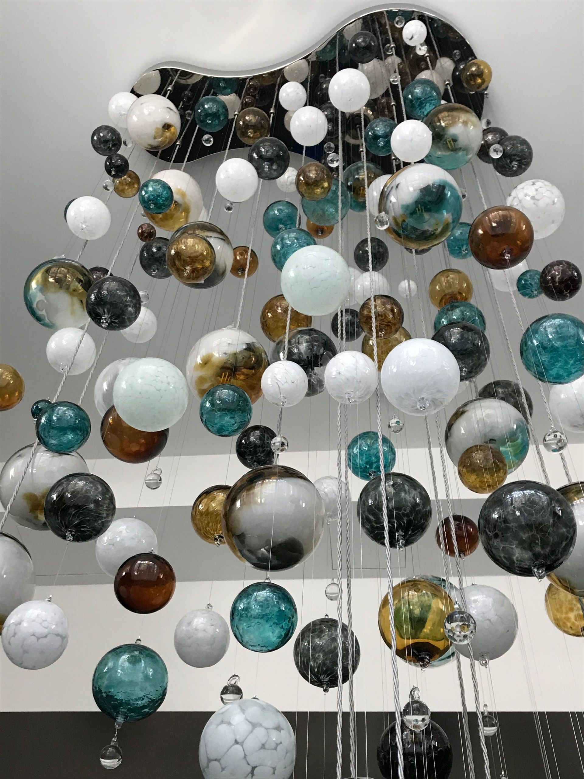 a Roast Designs mixed glass ball chandelier hanging from the ceiling