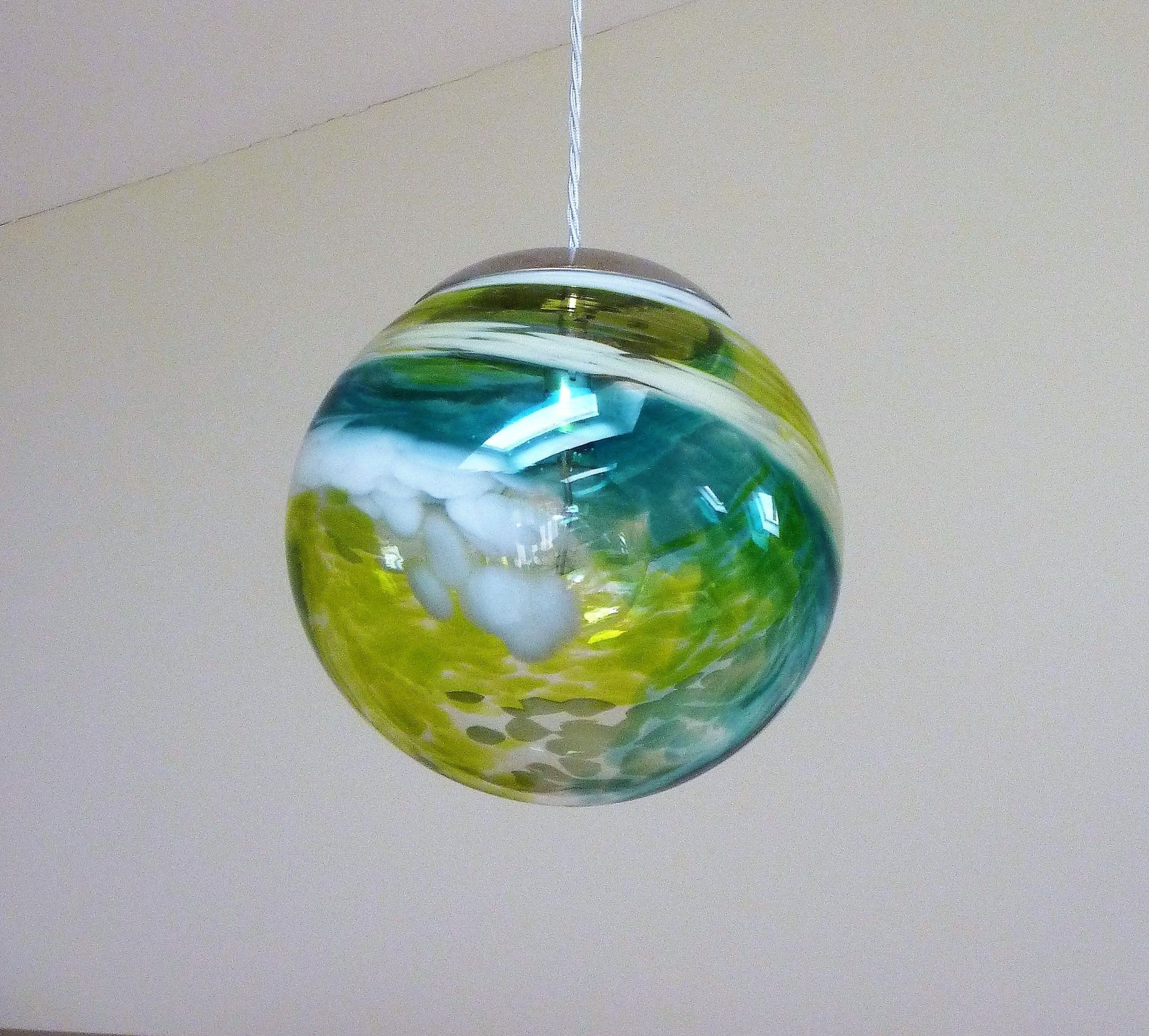 a Roast Designs green and yellow glass ball light hanging from a chain