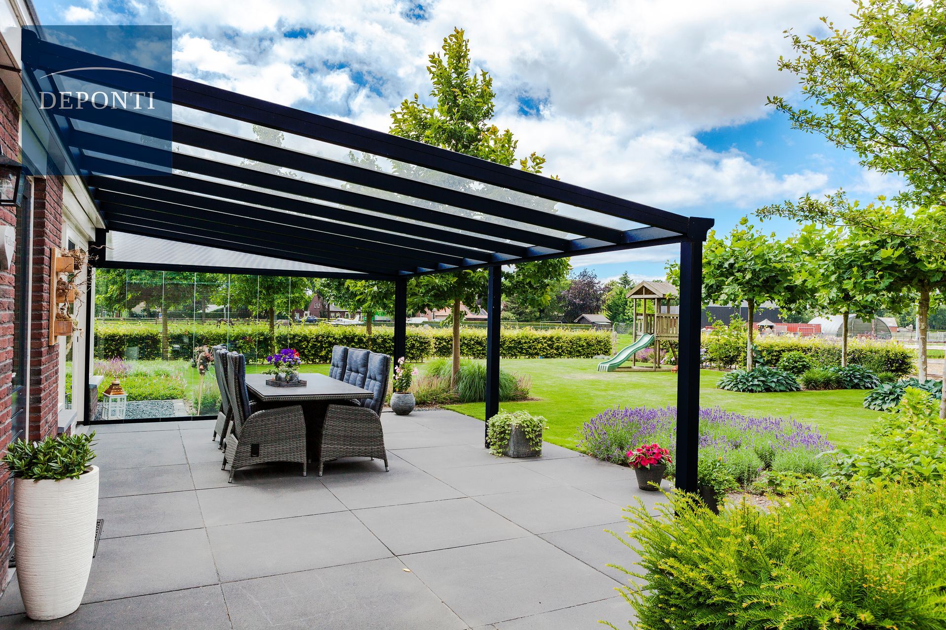 Deponti aluminium veranda with glass sliding panels to the side and a table and chairs under the canopy