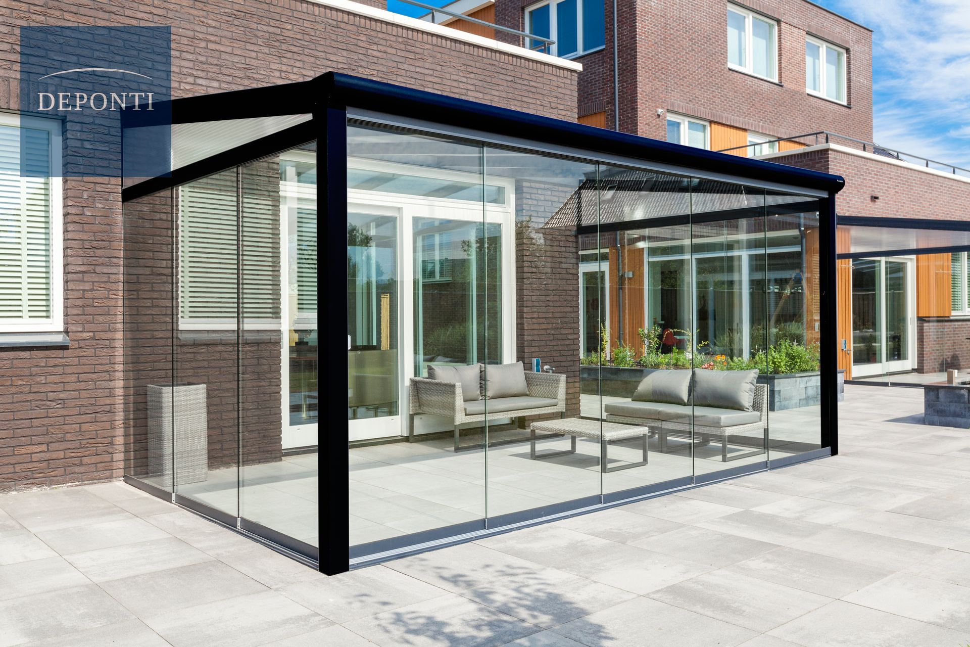 Premium Deponti aluminium veranda with glass sliding panels to the side and front and a table and chairs under the canopy