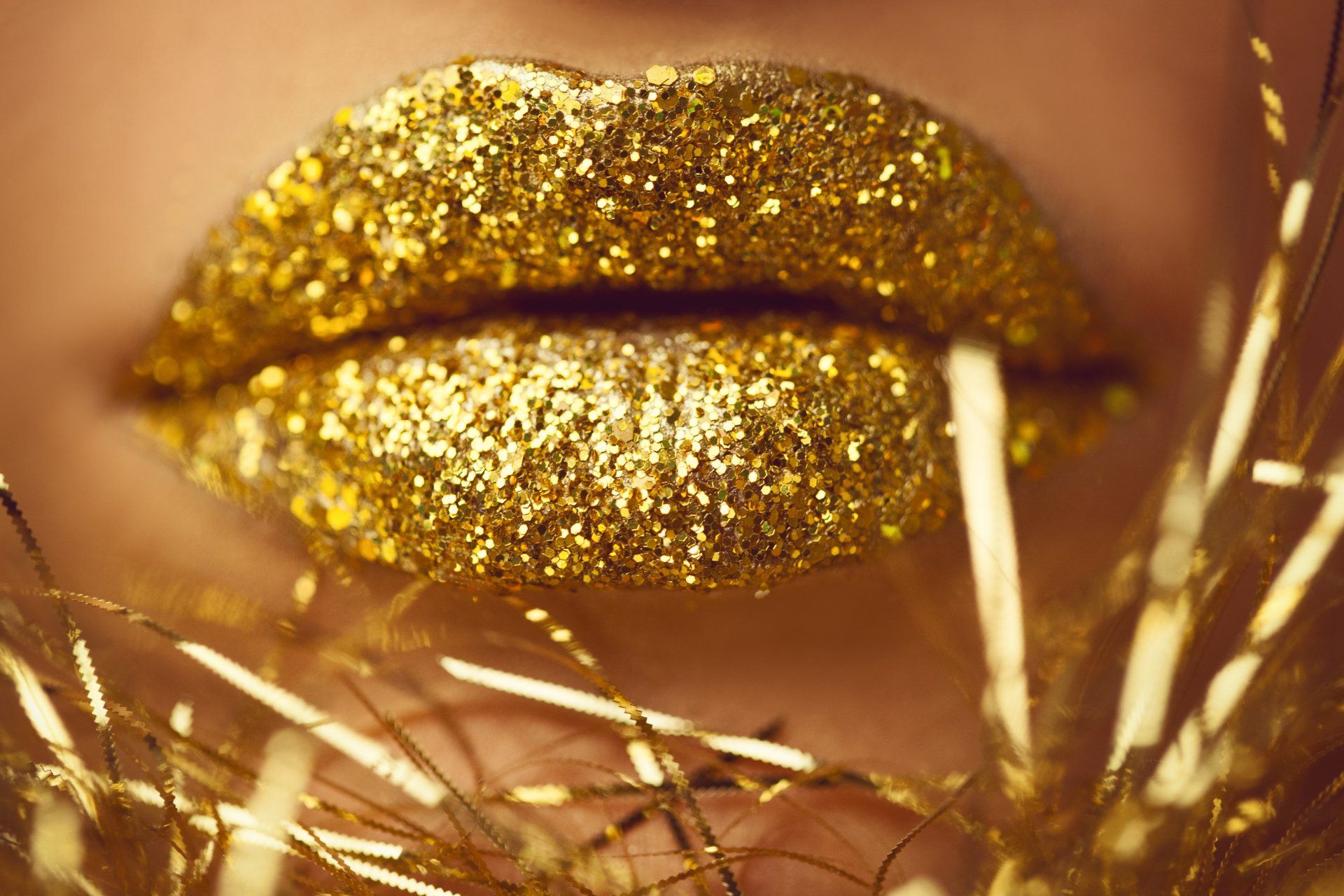a close up of a woman 's lips with gold glitter on them