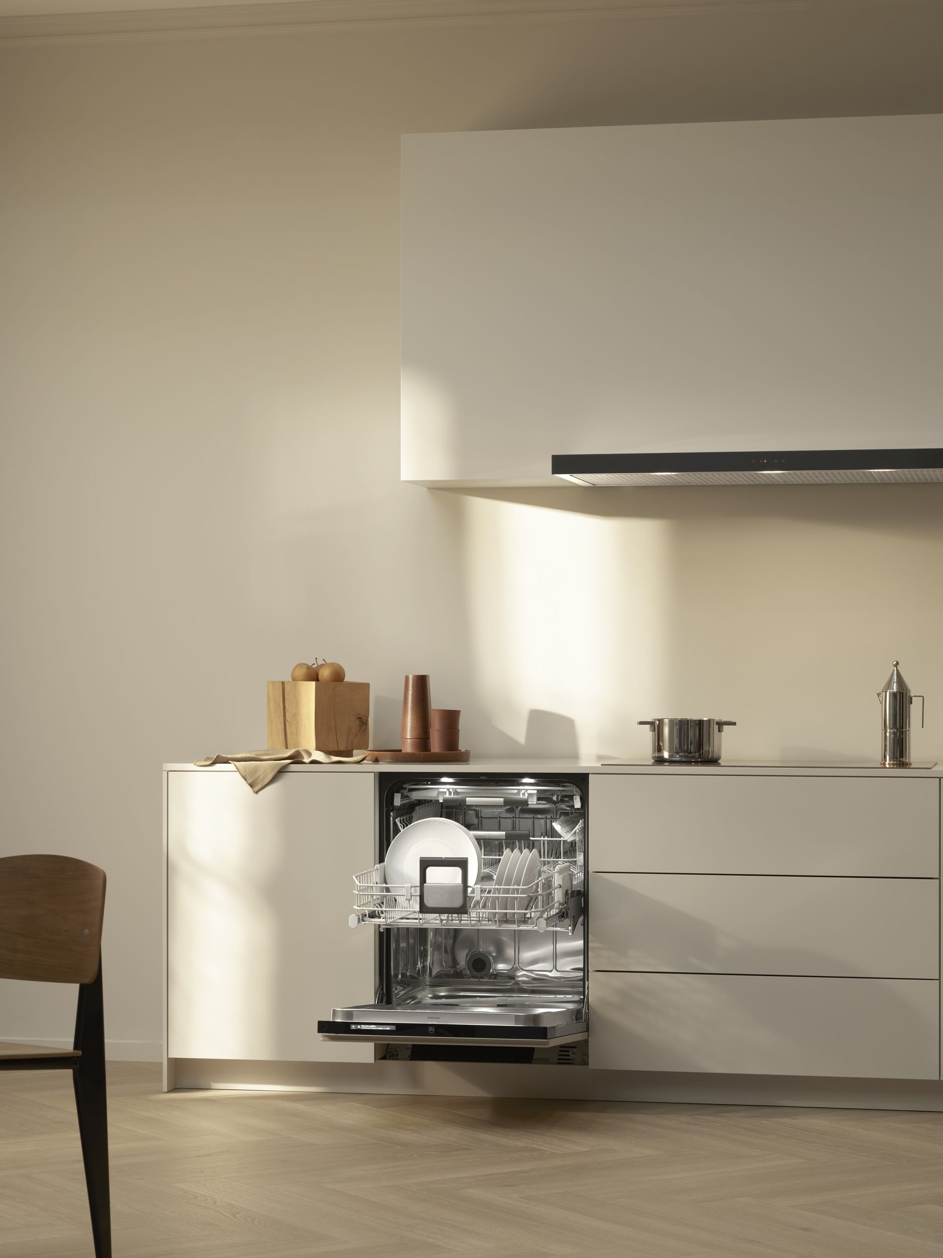 V-ZUG Adora V600 dishwasher unit door open in luxury kitchen showing internal drawers loaded with dishes