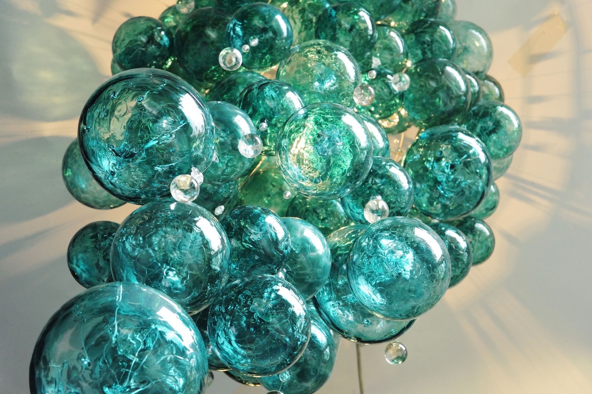 a Roast Designs green glass balls chandelier hanging from a ceiling