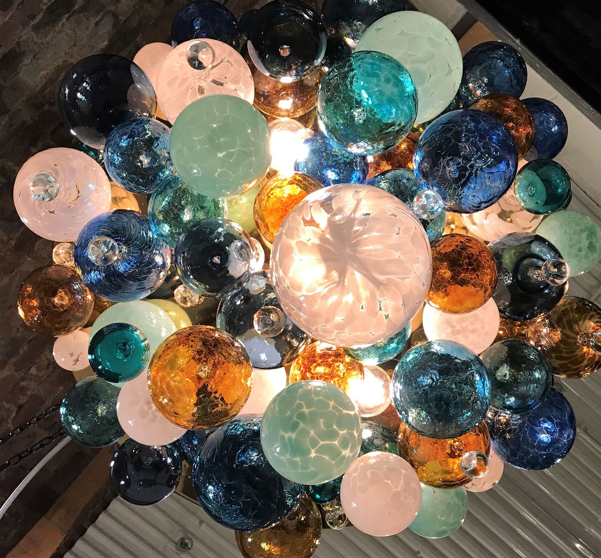 close up shot of a Roast Designs multi-coloured  glass balls  chandelier hanging from the ceiling
