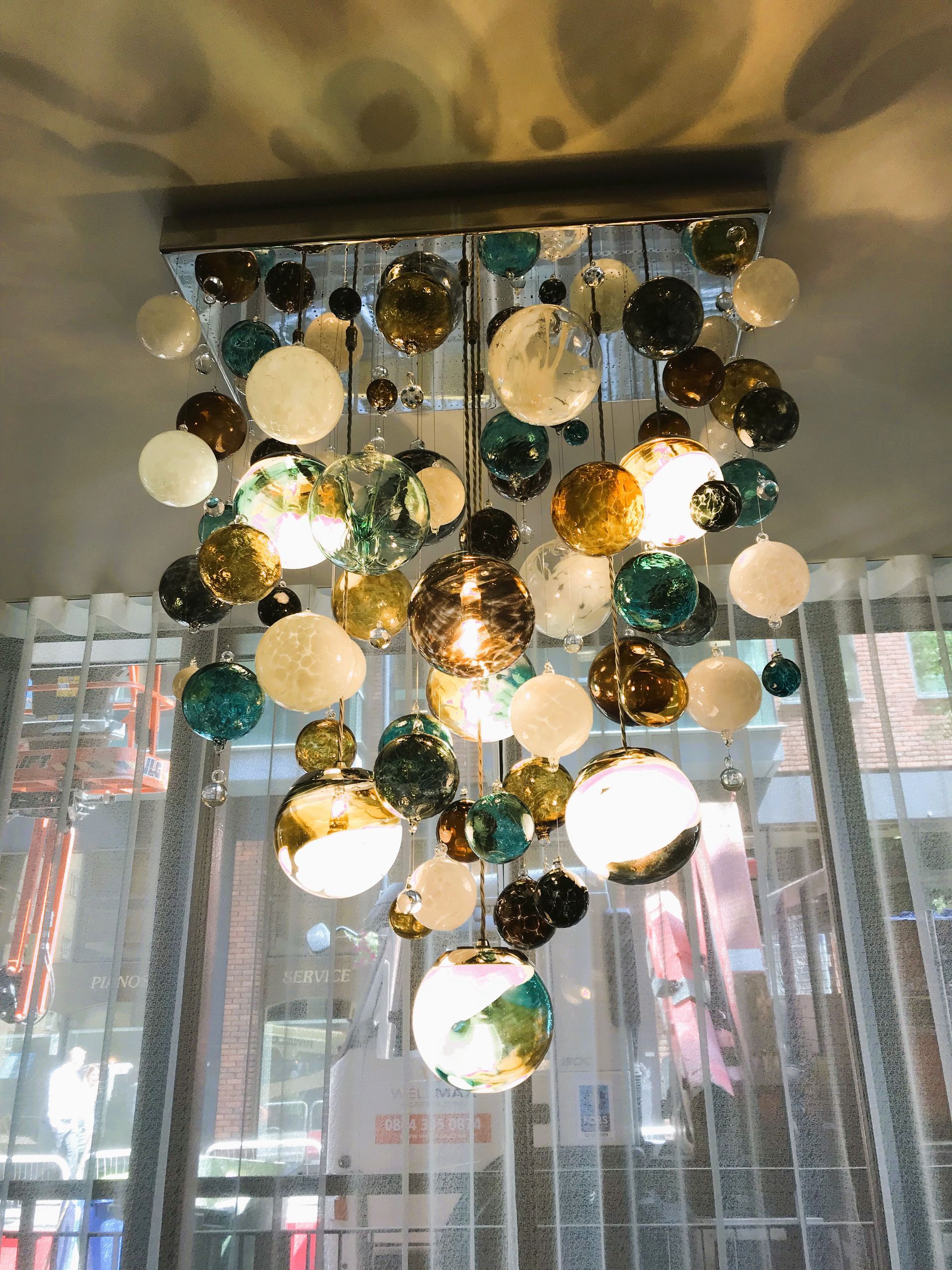a Roast Designs chandelier with many different colored glass balls hanging from the ceiling