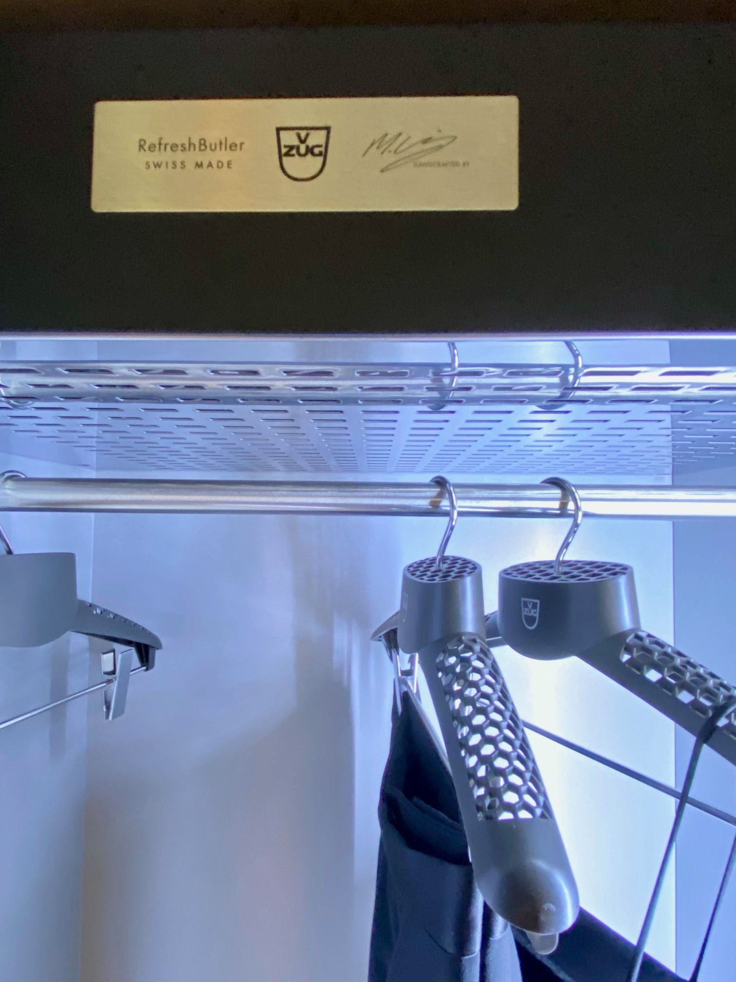 V-ZUG STUDIO LONDON REFRESH BUTLER WITH MACRO VIEW OF ALUMINIUM COAT HANGERS WITH PERFORATIONS TO ALLOW STEAM TO PASS