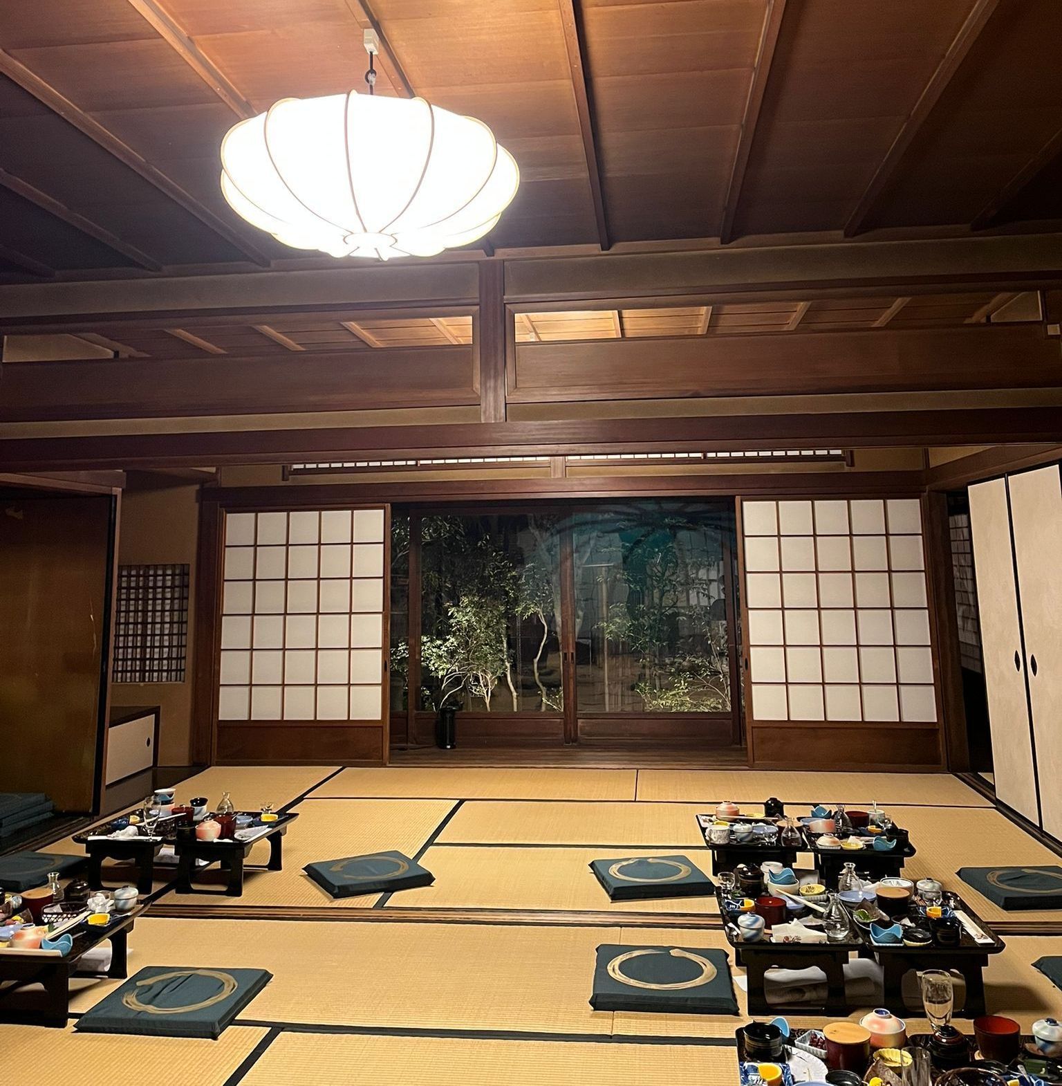 A large Japanese tearoom with tables and floor cushions