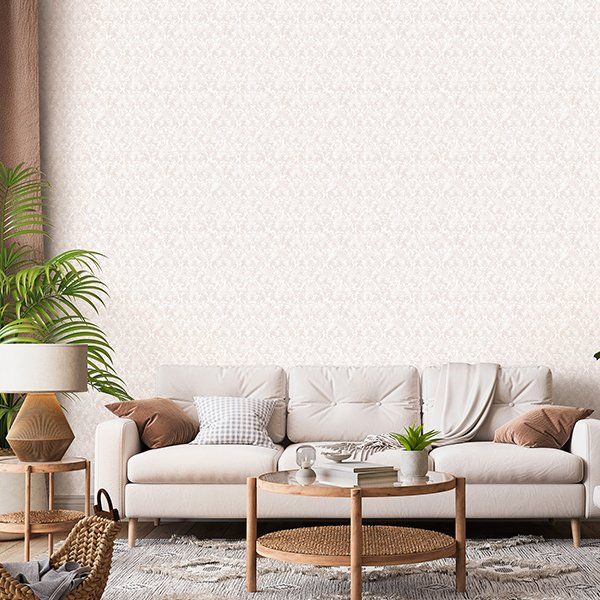 a living room with a white couch , wicker table , lamp , and plant .