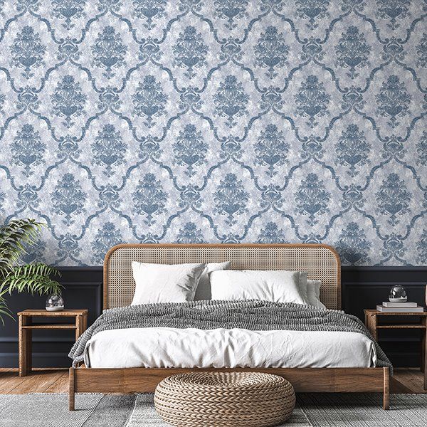 a bedroom with a bed , nightstands , and a blue and white wallpaper .