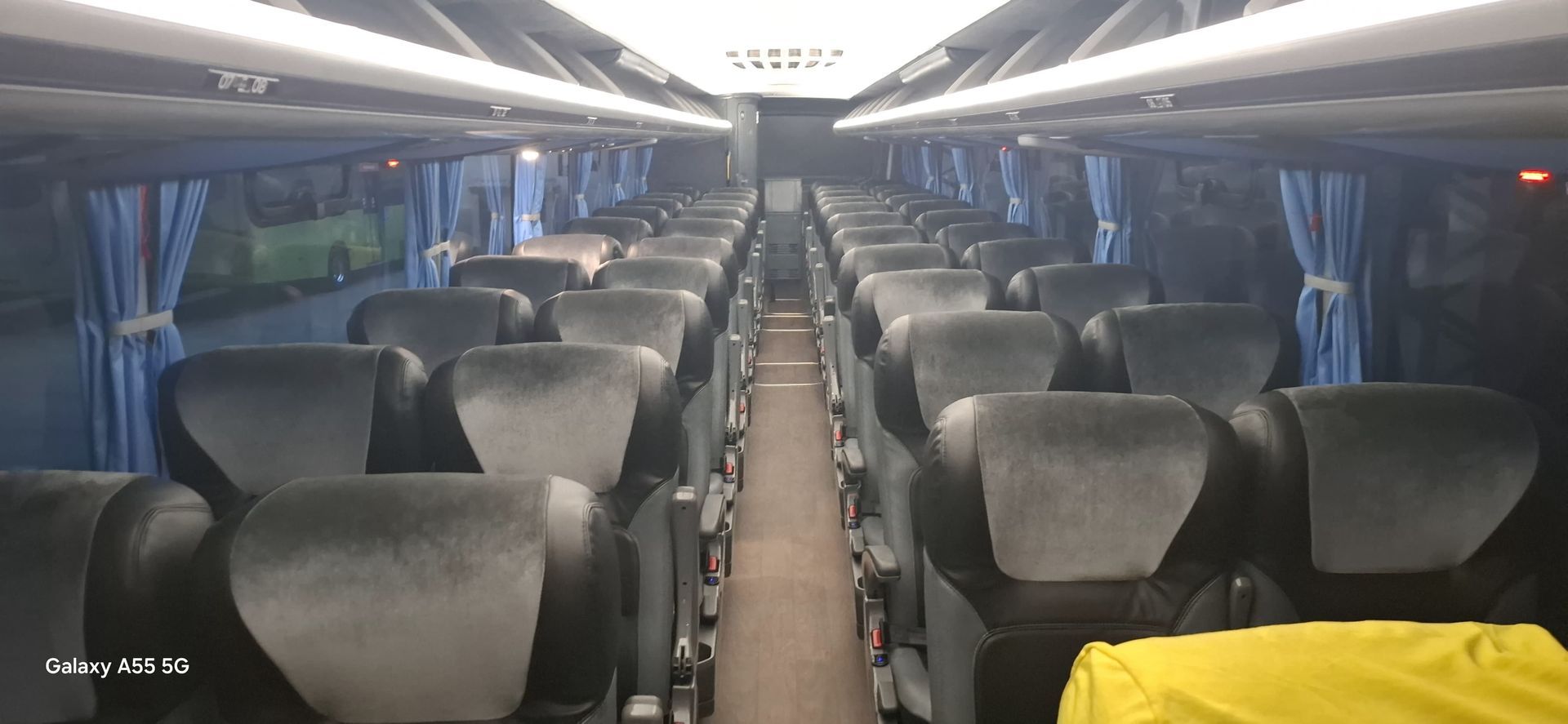 Ônibus cinza e branco com símbolos de acessibilidade.