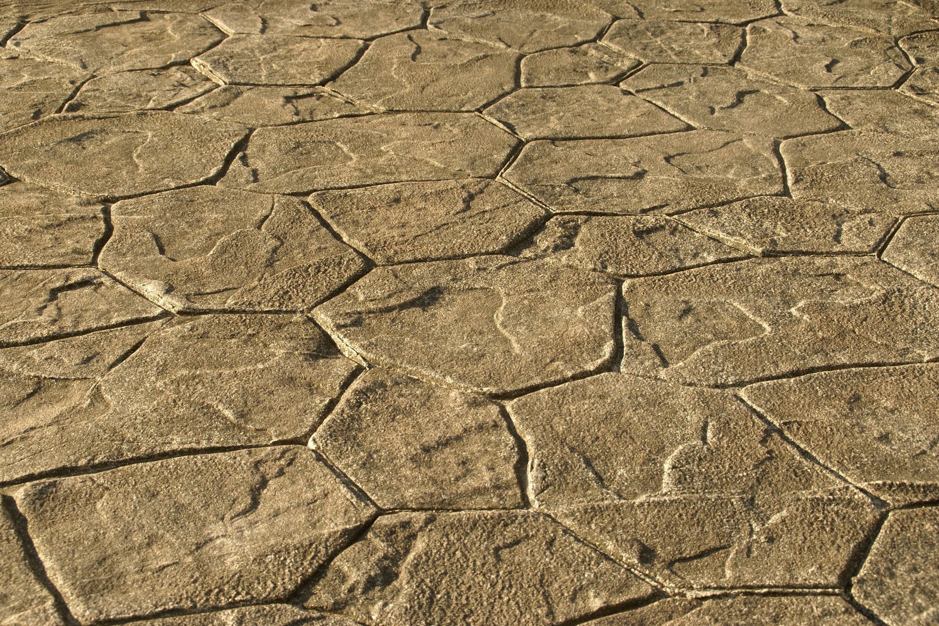 Brown, stamped concrete pavement with irregular, stone-like texture.