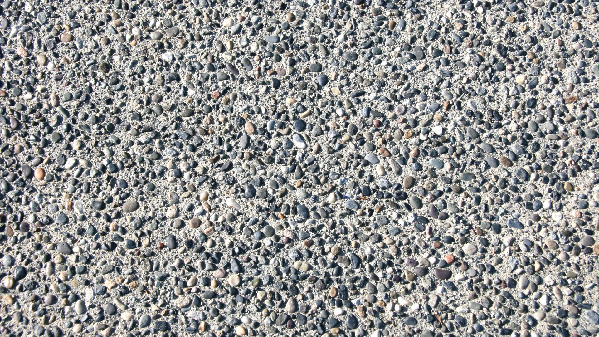 Gray asphalt surface texture with small pebbles.