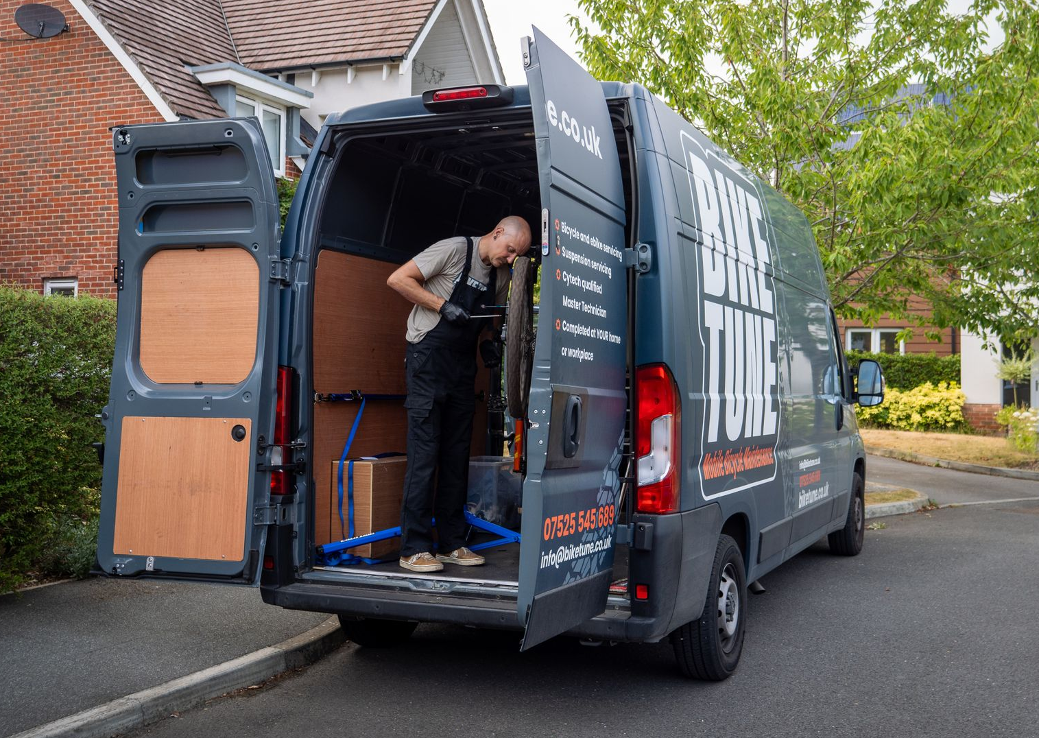 A person working inside a van with open doors, labeled 
