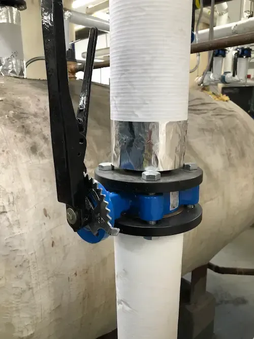 Commercial butterfly valve installation on large water pipe by licensed Oakville plumber