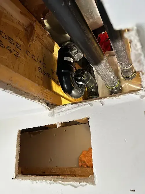 Drywall cut open in Oakville home to investigate hidden bathtub leak.