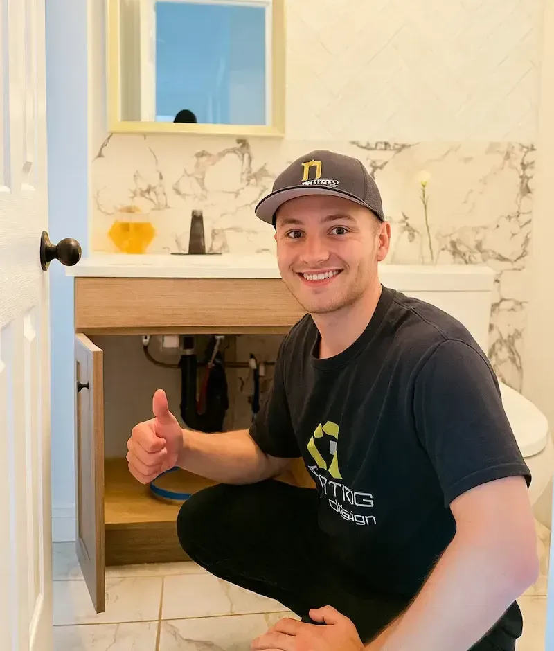 17 Plumbing plumber posing in front of bathroom sink vanity.