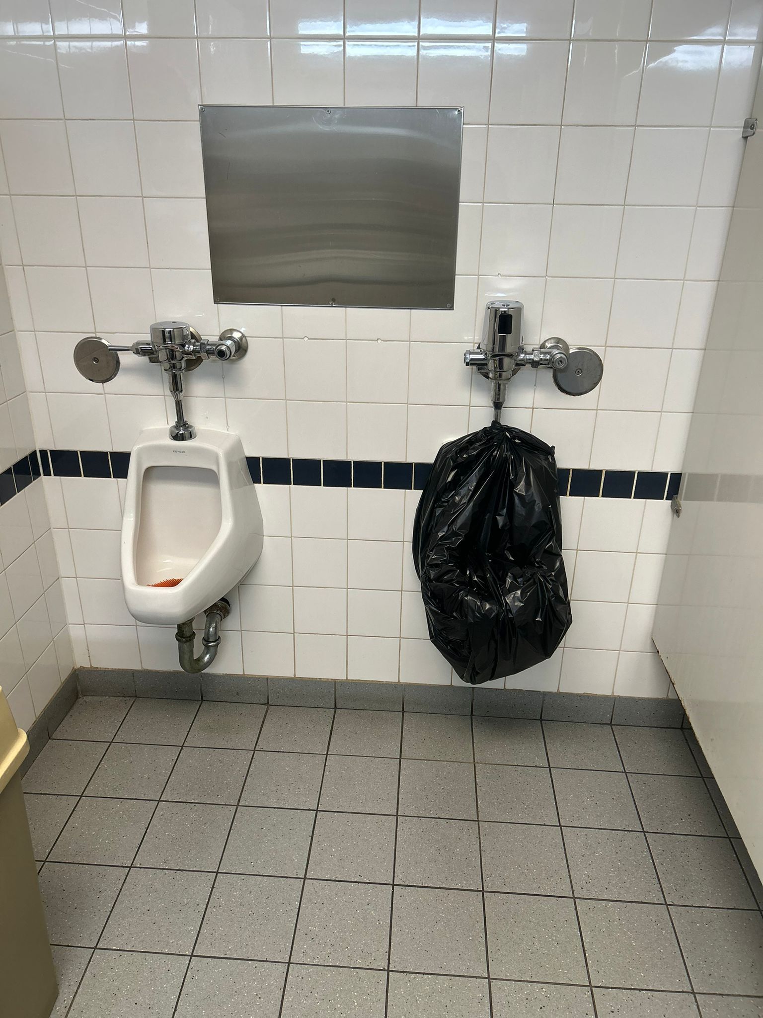 Upgraded commercial washroom with dual urinals installed and tiled walls by 17 Plumbing