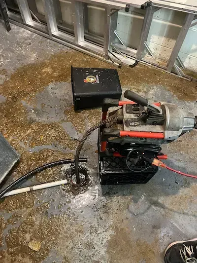 Professional plumber clearing a clogged main drain in Oakville