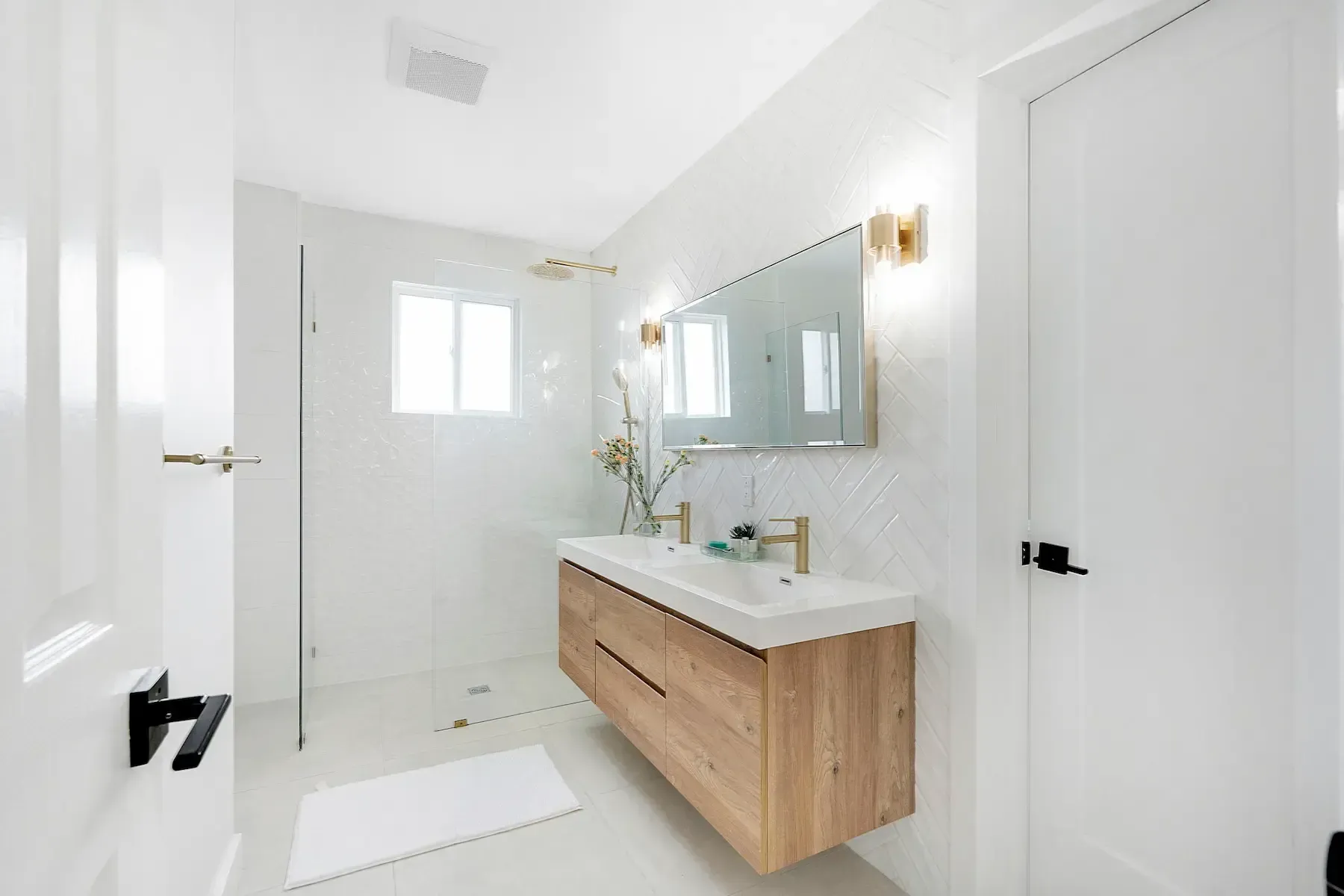 A bathroom with a double sink and a walk in shower, newly renovated