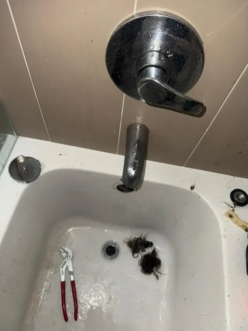 clogged bathtub drain with hair blockage being cleared during drain cleaning oakville