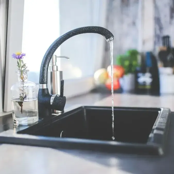 Plumber installing sink in a kitchen.