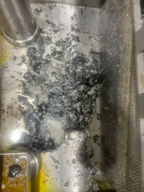 Severe grease buildup inside a commercial grease trap before professional cleaning.