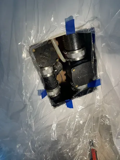 Cast iron drain pipes with couplings and clamps accessed for inspection during plumbing repair in Oakville condominium