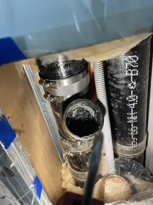 Clogged kitchen drain pipe with heavy buildup inside condominium plumbing system
