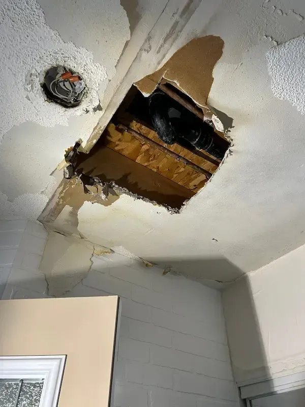 Water damage to ceiling discovered during leak investigation after frozen pipe burst in Oakville residence.