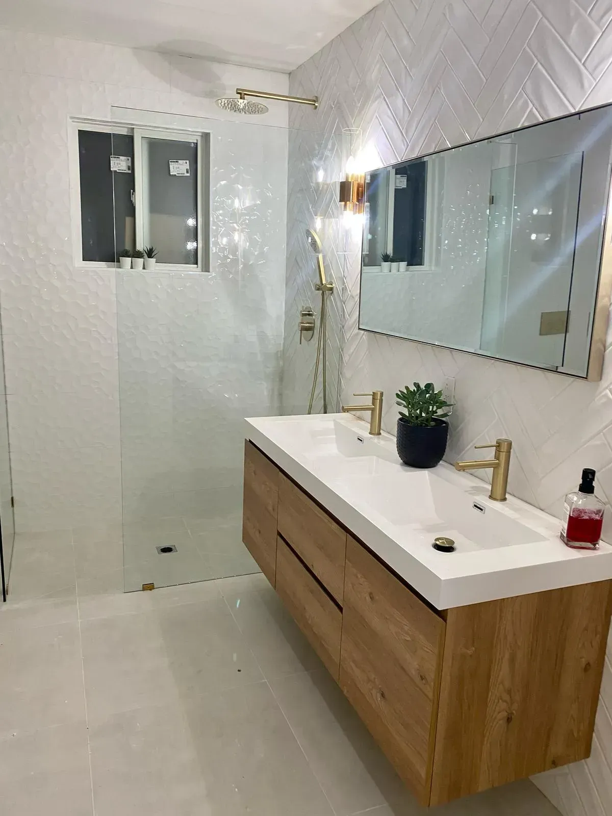 A bathroom with a double sink and a walk in shower, newly renovated