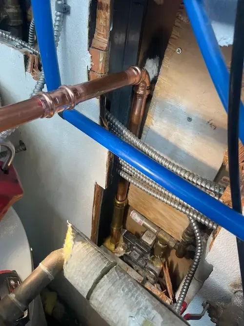 Completed pinhole leak repair on hot water line with new copper fittings and pipe insulation