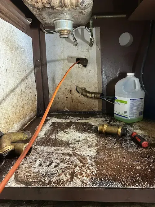 Powerflushing drain cleaning service at a Tim Hortons commercial kitchen in Oakville, featuring professional-grade equipment used to clear grease and food buildup from under-sink drains
