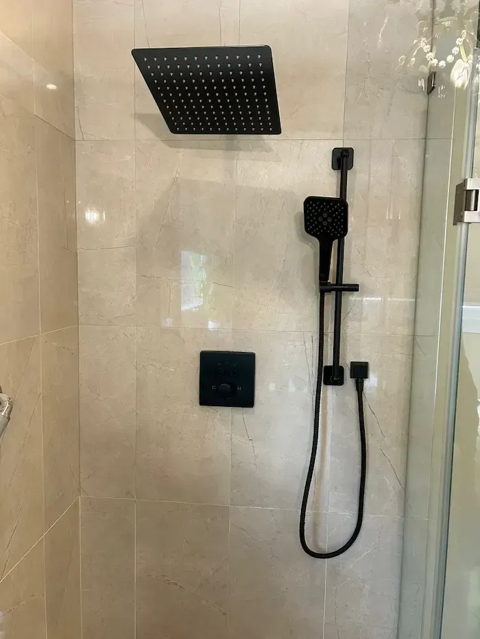 Licensed Oakville plumber replacing faulty shower valve behind bathroom tile
